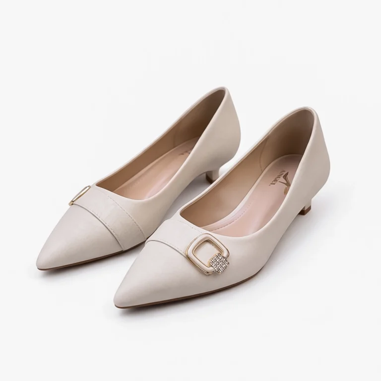 Pair of women's off-white pointed toe heels with golden stone buckle.