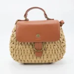 Front view of women's natural beige woven straw tote bag with ring decoration in Bangladesh